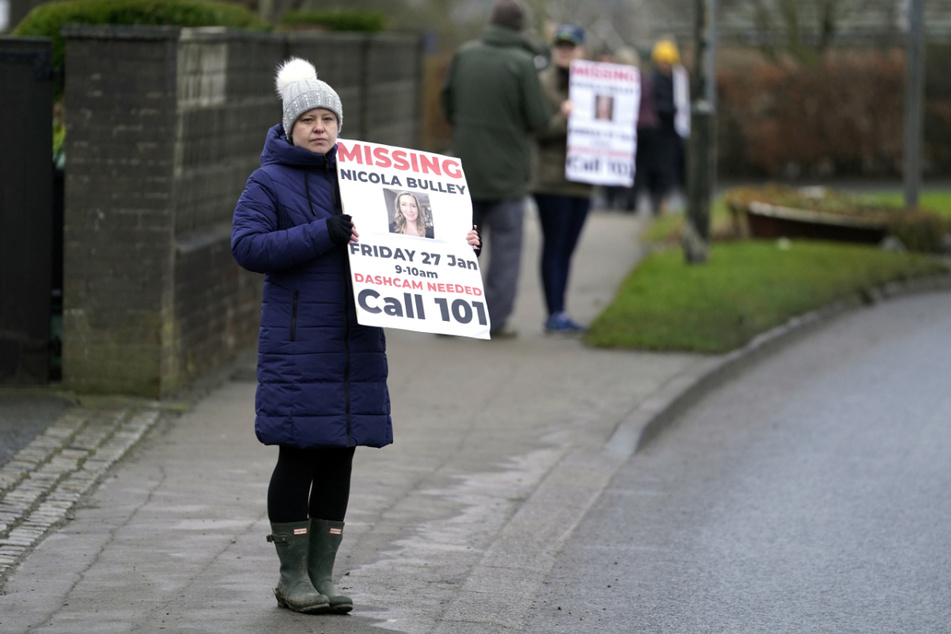 Eine Einwohnerin von St Michael's on Wyre steht mit einem Vermissten-Schild am Straßenrand.