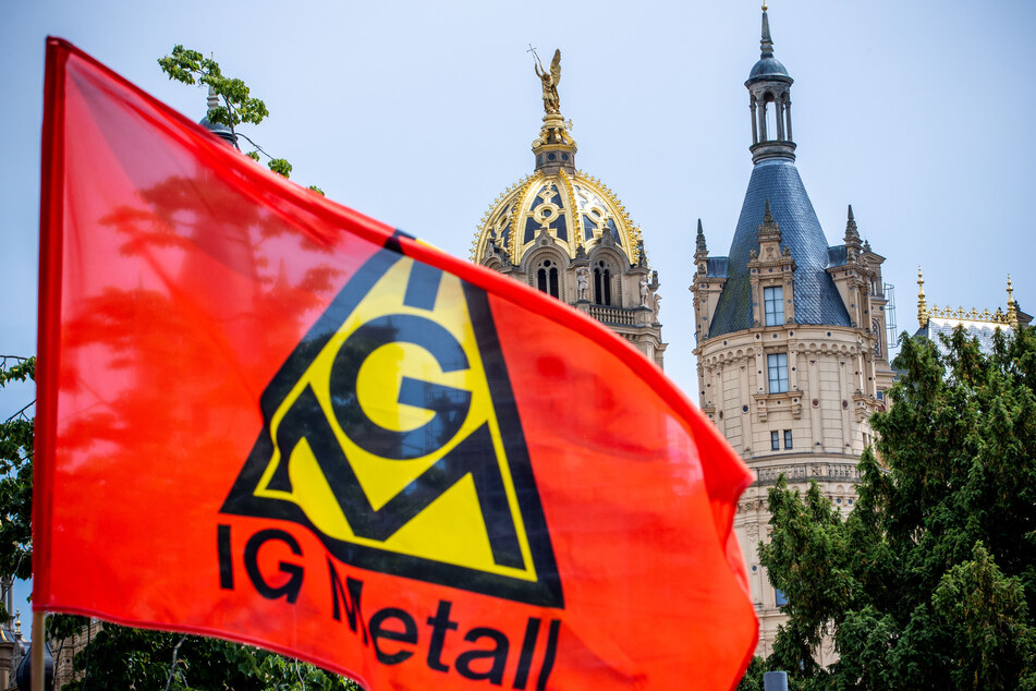 Eine Fahne der IG Metall weht bei einer Demonstration von Werftarbeitern vor dem Landtagssitz.