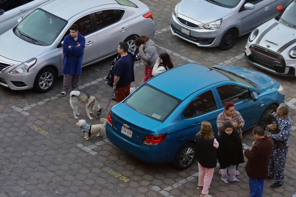 Dozens of people take shelter in a parking lot with their pets after a 6.5 magnitude earthquake strikes in Mexico City on Friday.