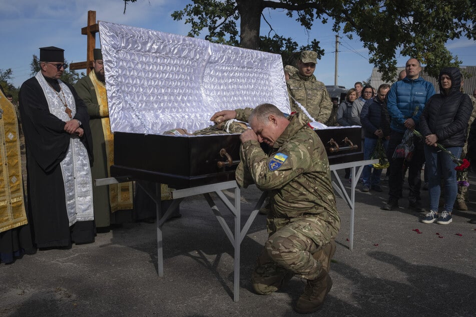 Ein ukrainischer Soldat trauert vor einem Sarg, während einer Beerdigungszeremonie für einen getöteten ukrainischen Bataillonskommandeur.