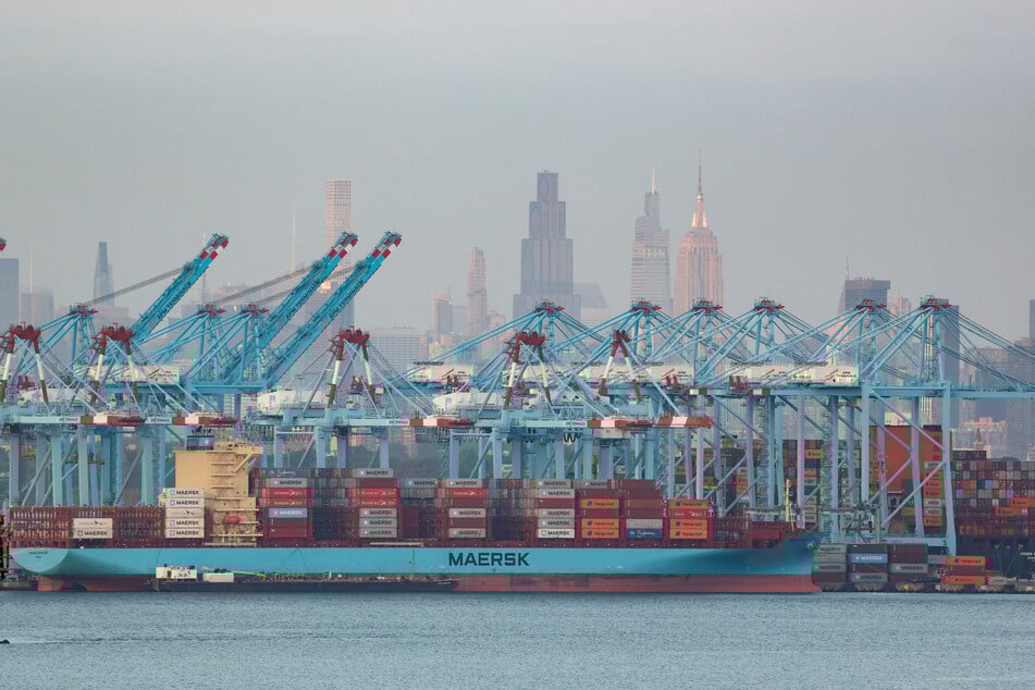 Cargo ships and shipping containers are seen at the Port Jersey Container Terminal, with the Manhattan skyline in the distance, on September 22, 2025.