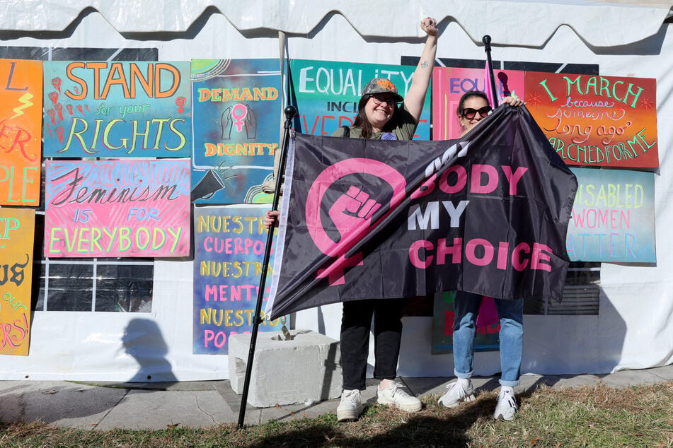 Demonstrators are seen with a flag during the "We Won't Go Back" Women's March To The White House on Saturday in Washington, DC.