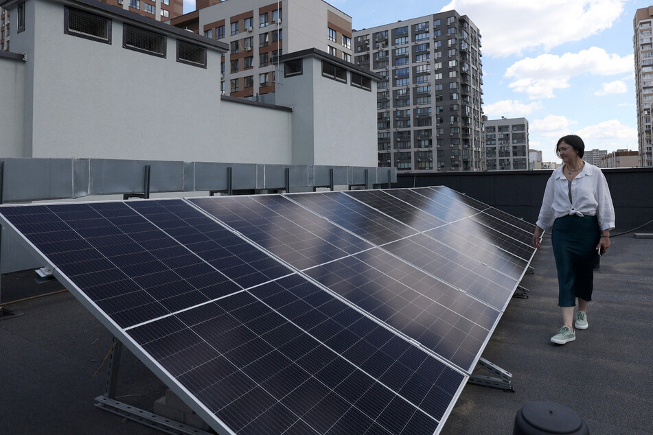 The founder of the private school Spilno School, Anastasia Kireeva-Kislynska, demonstrates the solar panels on the roof of her school during a partial electricity blackout in Kyiv on June 18.