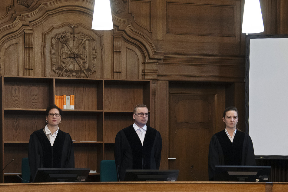 Der Vorsitzende Richter (M.) steht im Verhandlungssaal des Berliner Landgerichts.