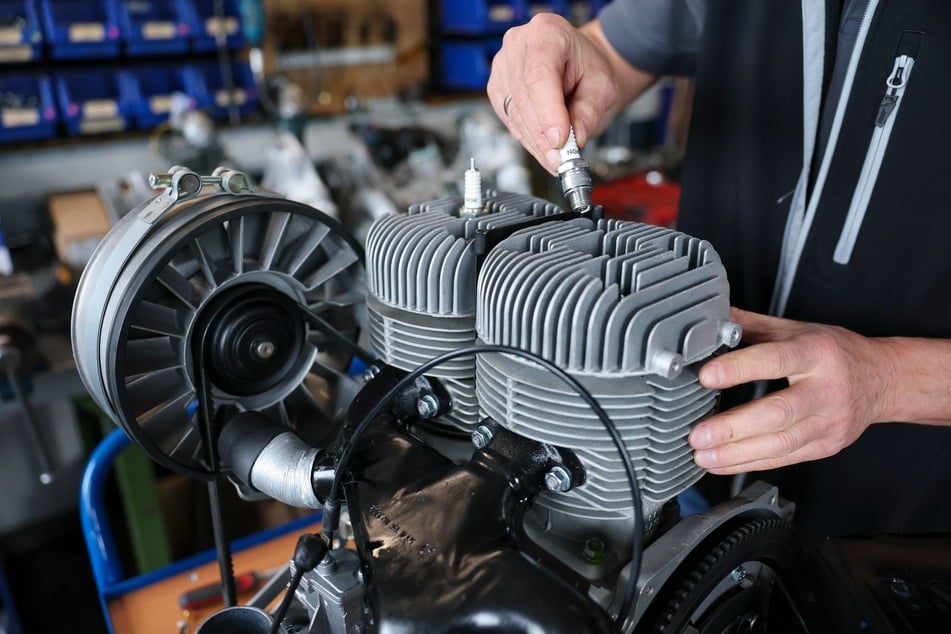 Einfach und unverwüstlich: Frank Hofmann, Chef der Trabantwelt Zwickau, schraubt eine Zündkerze in den Zylinderkopf eines Zweitaktmotors für einen Trabant 601.