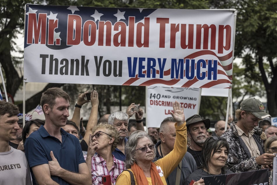 White South Africans supporting President Donald Trump and tech billionaire Elon Musk gather in front of the US Embassy in Pretoria on February 15, 2025.