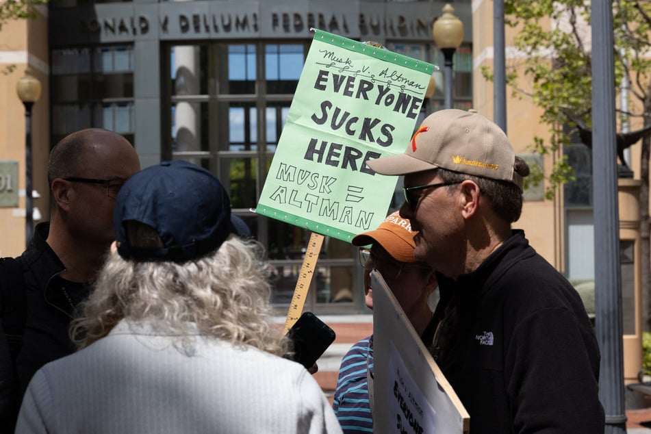 Demonstrators protest outside the courthouse at the Ronald V. Dellums Federal Building as jury selection begins in the lawsuit between Elon Musk and OpenAI on Monday in Oakland, California.