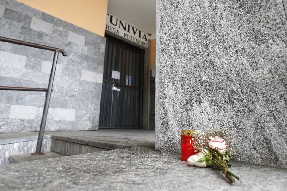 Blumen und eine Kerze liegen vor der Abfahrtsstation der Seilbahn von Stresa nach Mottarone. Beim Absturz einer Gondel einer Seilbahn am norditalienischen Lago Maggiore am 23. Mai haben 14 Menschen ihr Leben verloren.