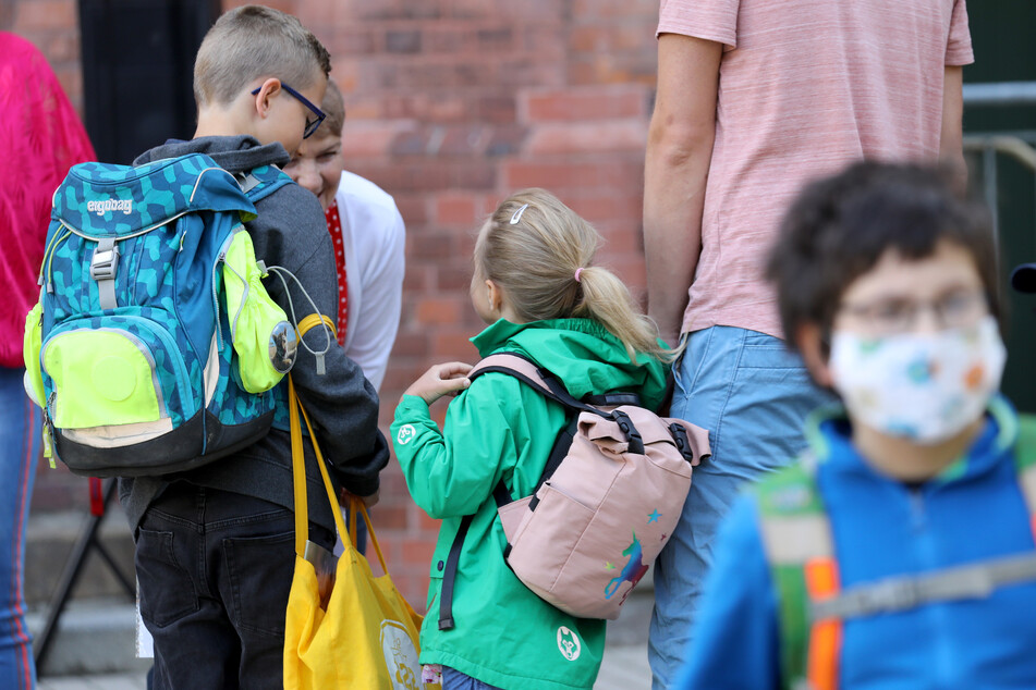 Schüler werden von ihren Eltern zur Schule gebracht.