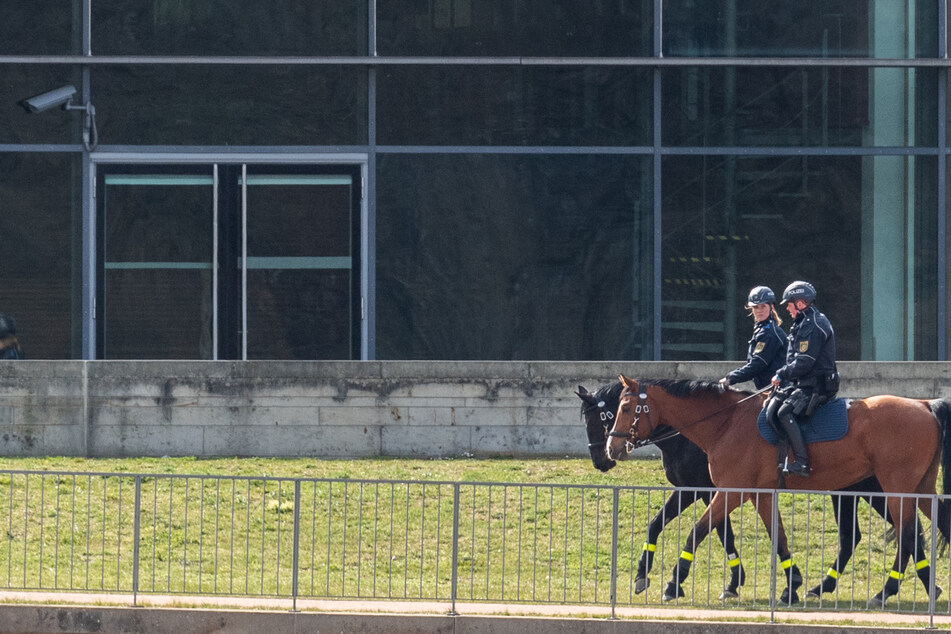 Polizisten auf Pferden patrouillieren am Elbufer hinter dem Internationalen Congress Center (ICC).