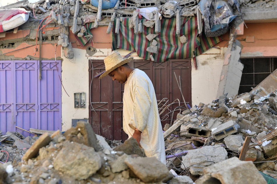Ein Bewohner geht nach dem verheerenden Erdbeben im Dorf Mzouda in der marokkanischen Provinz Chichaoua an zerstörten Häusern und Bauschutt vorbei.