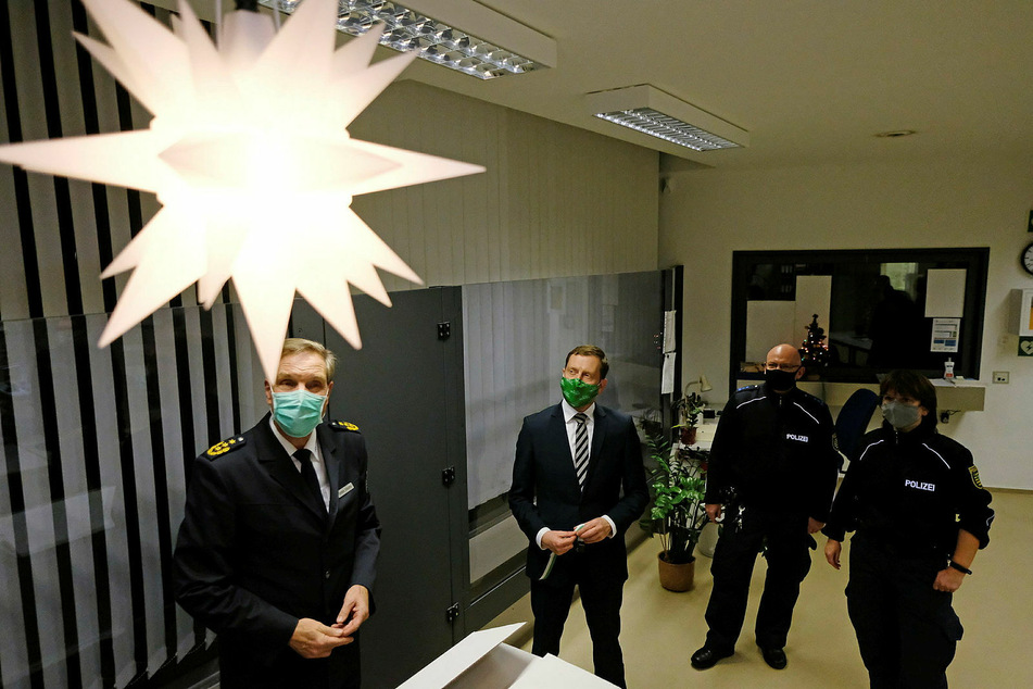 Gemeinsames Sterngucken: Leipzigs Polizeichef Torsten Schultze, Regierungschef Michael Kretschmer und zwei Beamten der Connewitz-Wache (v.l.) ist ein Licht aufgegangen.