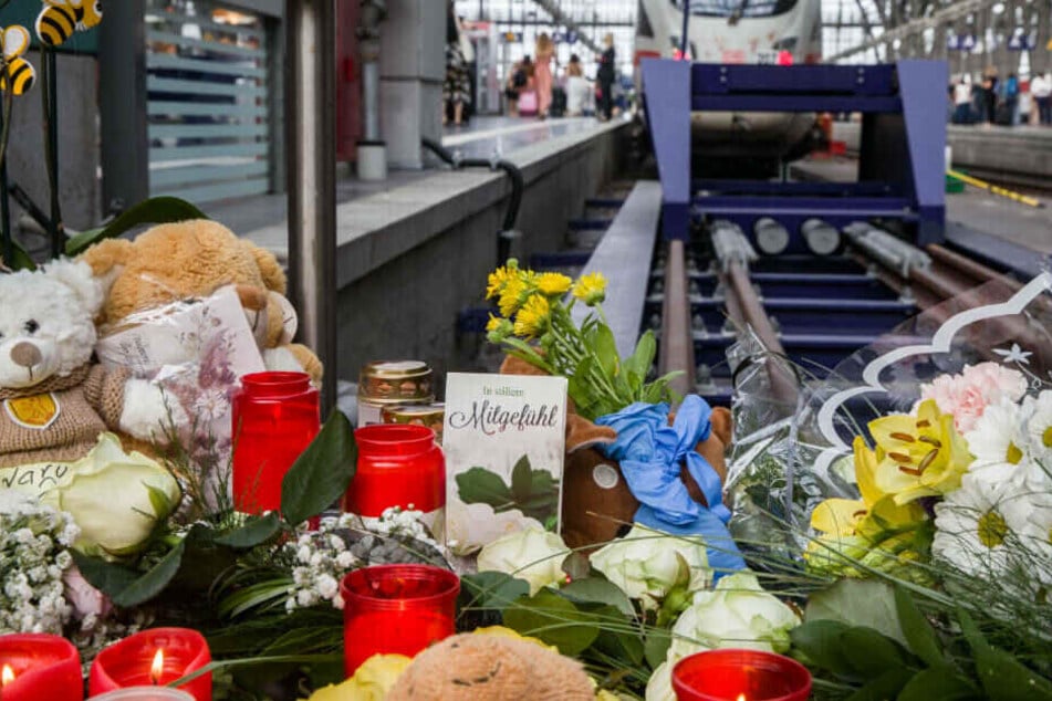 Eine Karte mit der der Aufschrift "In stillem Mitgefühl" steht am Bahnsteig 7 im Frankfurter Hauptbahnhof zwischen Kerzen, Plüschtieren und abgelegten Blumen.