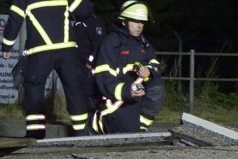 Ein Feuerwehrmann nimmt Messungen an der Straße vor.