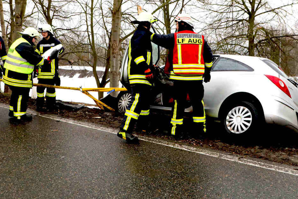 Einsatzkräfte müssen sich um das Auto kümmern, das einen Hang hinunter zu rutschen droht.
