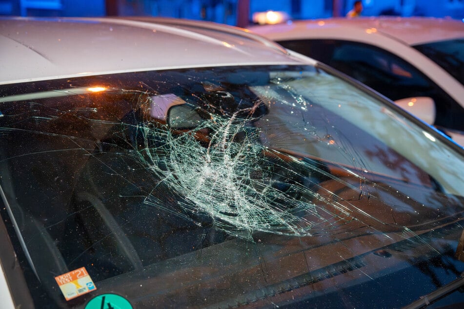 Die Frontscheibe eines geparkten Autos wurde durch Trümmer beschädigt.