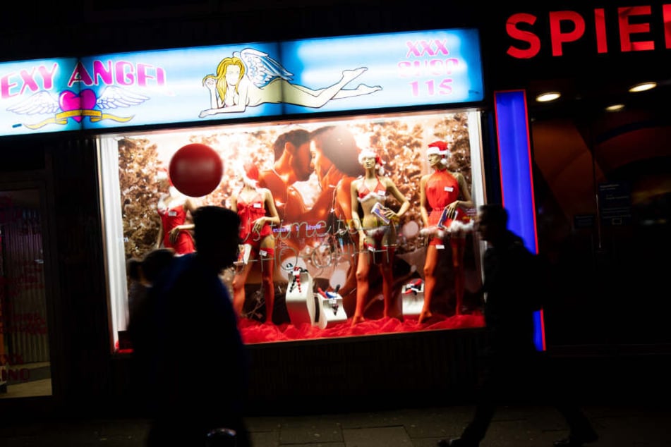 Fußgänger passieren ein Erotik-Geschäft auf der Reeperbahn.