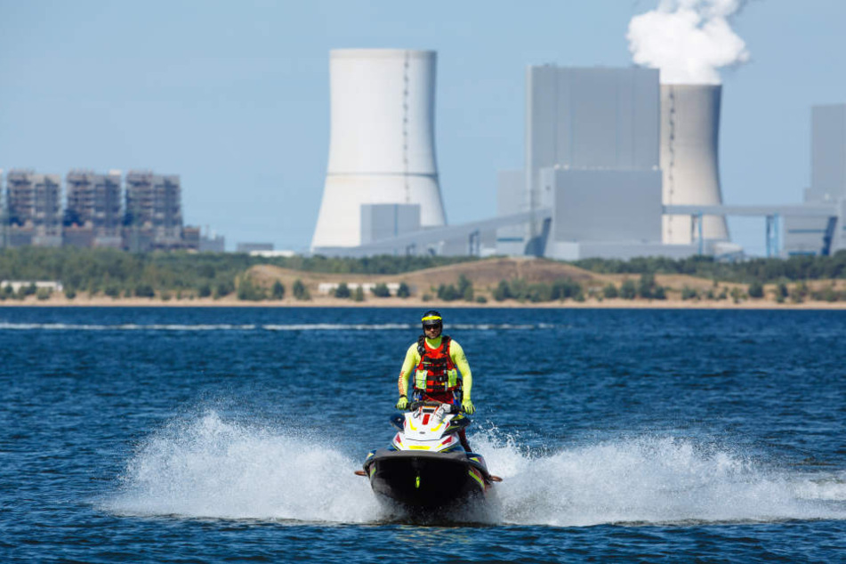 Vor den Kühltürmen des Boxberger Kraftwerks schießt Jens Kammann mit seinem Rettungs-Jetski über den Bärwalder See.
