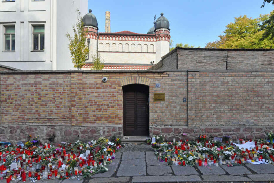 Blumen und Kerzen liegen nach dem rechtsextremen Anschlag neben der Tür zur Synagoge in Halle.