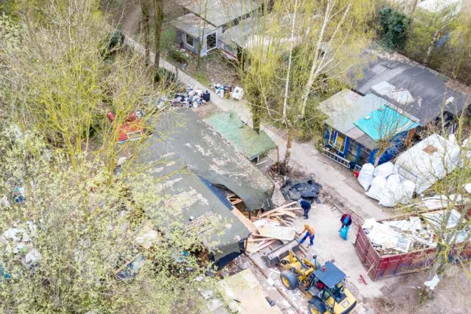 Ein Bagger steht vor der bereits zum Teil abgerissenen Parzelle des mutmaßlichen Täters auf dem Campingplatz Eichwald