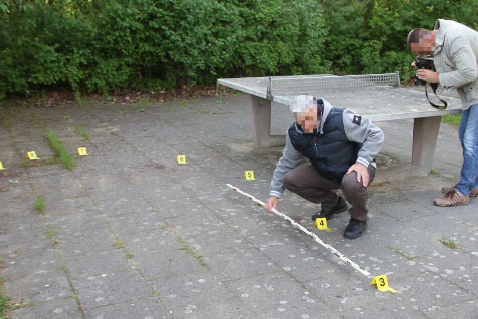 Zwei Polizeibeamte sichern Spuren an einem Spielplatz unweit des Fundortes des toten Säuglings.