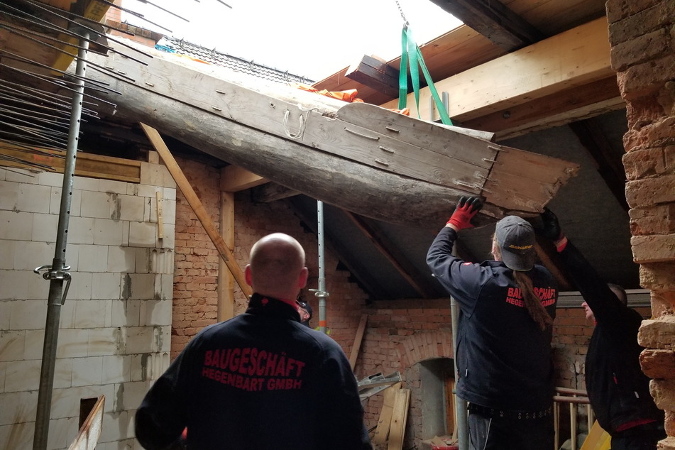Vorsichtig bugsierten Arbeiter den Einbaum durch ein Loch im Dach in Hoheneck.