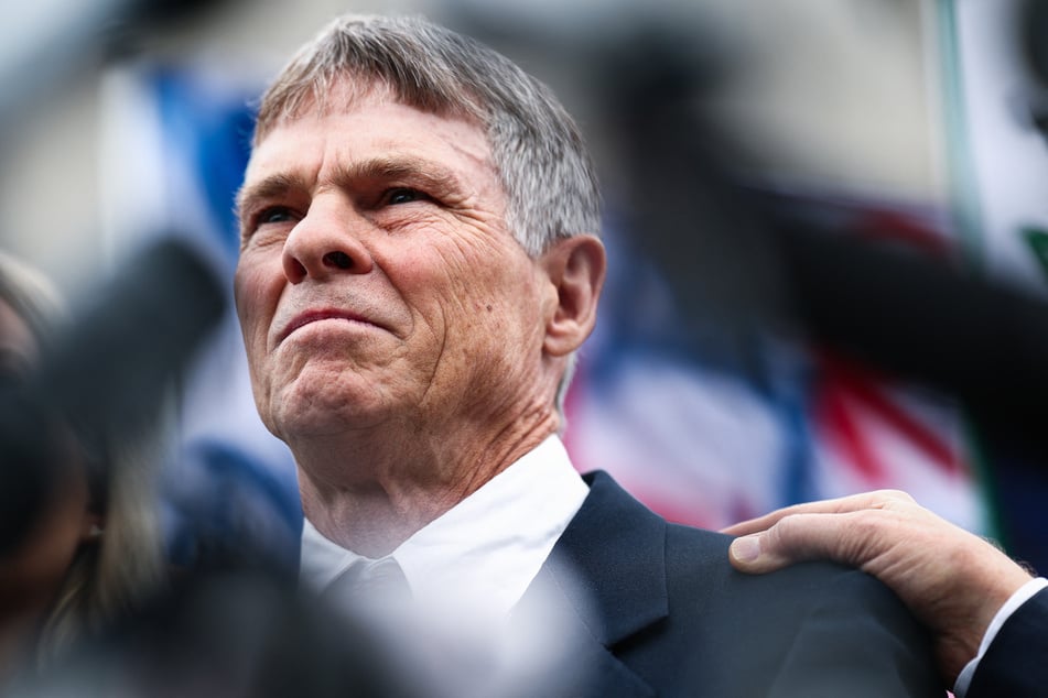 Former Olympian David Hearn (pictured) stands with his attorney Norman Eisen as he speaks to reporters and protestors gathered after his arraignment at Moultrie Courthouse on July 9, 2026, in Washington, DC.