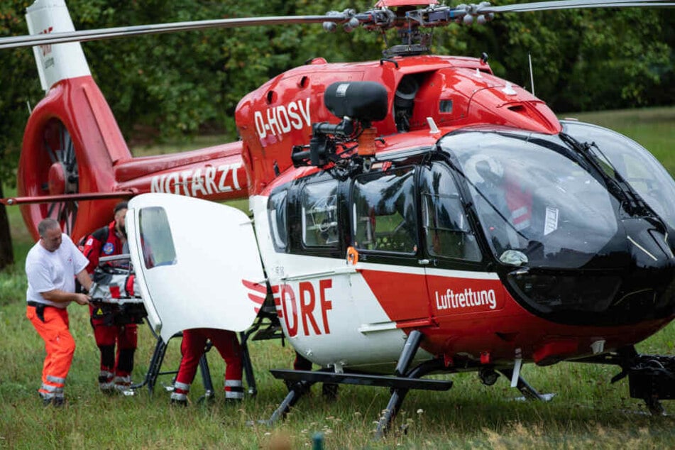 Rettungskräfte bringen das Mädchen in den Hubschrauber.