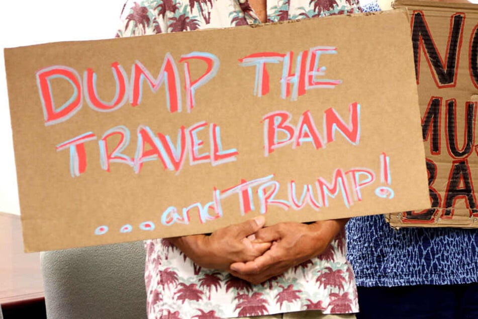 Nicht allen gefällt die strikte Einreisepolitik von Donald Trump. Hier halten Gegner ein Banner hoch.