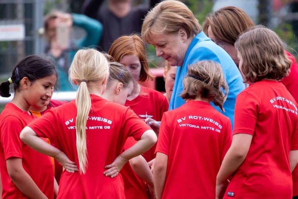 Kanzlerin Angela Merkel (63, CDU) signiert die Trikots der Fußballerinnen.