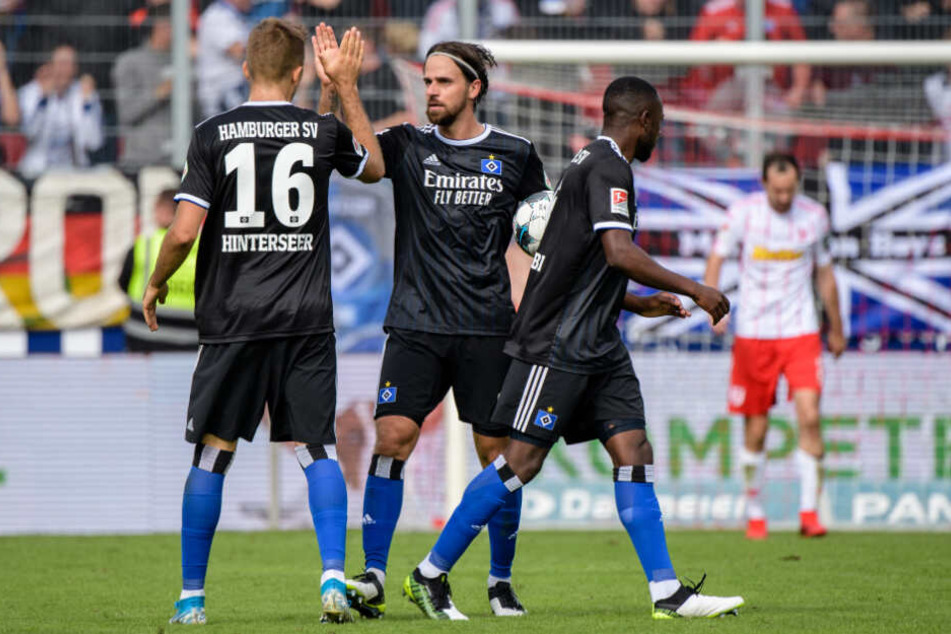Lukas Hinterseer (von links nach rechts), Martin Harnik und David Kinsombi klatschen nach dem Eigentor von Regensburg zum 1:1 ab.