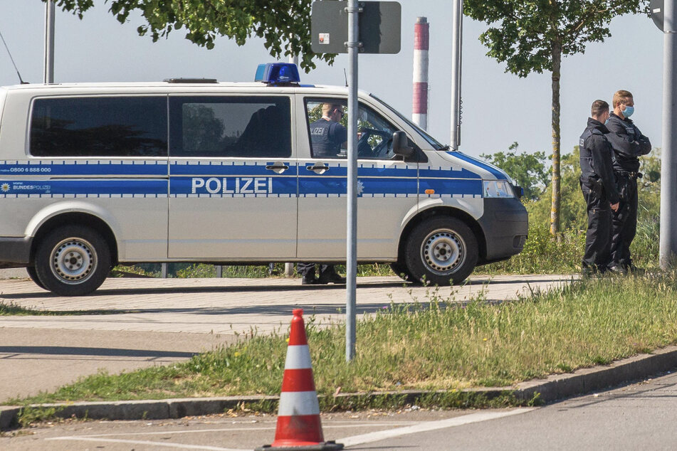 Beamte und ein Einsatzfahrzeug der Bundespolizei stehen nahe einer Brücke am Grenzübergang nach Frankreich. (Archivbild)