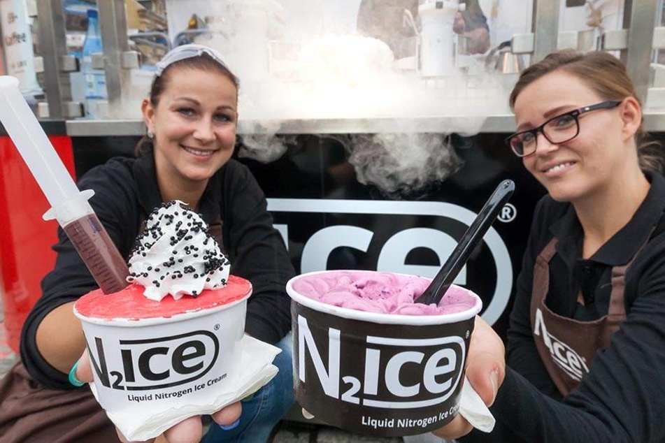 Janine Bittrich (29, l.) und Anne Georgi (31) mit durch Stickstoff schock-gefrostetem Eis. Dahinter bereitet Uwe Kleppisch (40) eine weitere Portion zu.
