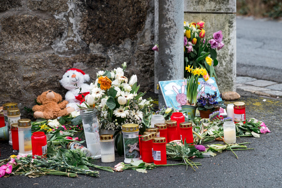 An einer Mauer vor dem Kinder- und Jugendhilfezentrum, in dem die Zehnjährige tot aufgefunden wurde, liegen Blumen, Kuscheltiere und Kerzen. (Archiv)