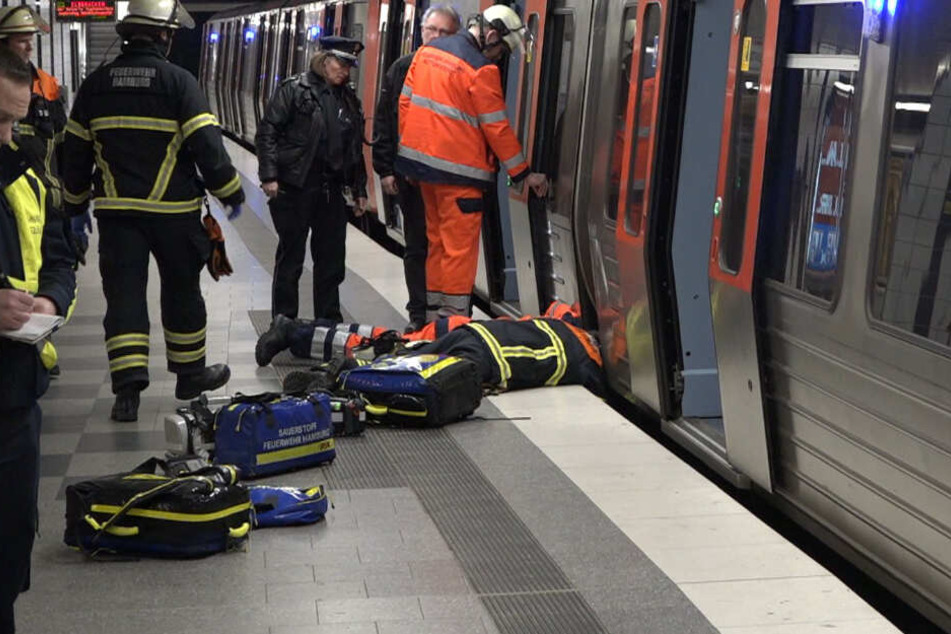 Ein Feuerwehrmann liegt am Boden und spricht mit dem Jugendlichen, der ins Gleisbett gefallen war und sich in einen Zwischenraum retten konnte.