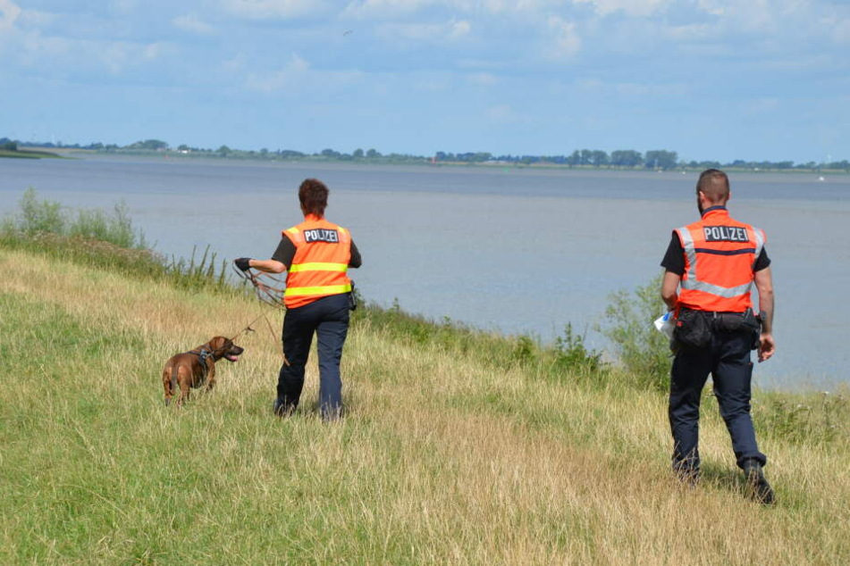 Beamte suchen das Ufer der Elbe nach Spuren ab.