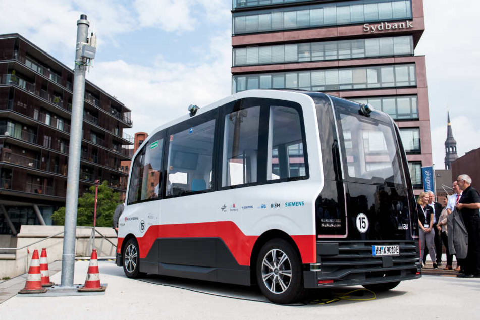 Ein autonom fahrenden Elektro-Kleinbus der Hamburger Hochbahn steht neben einer Datensäule in der HafenCity.
