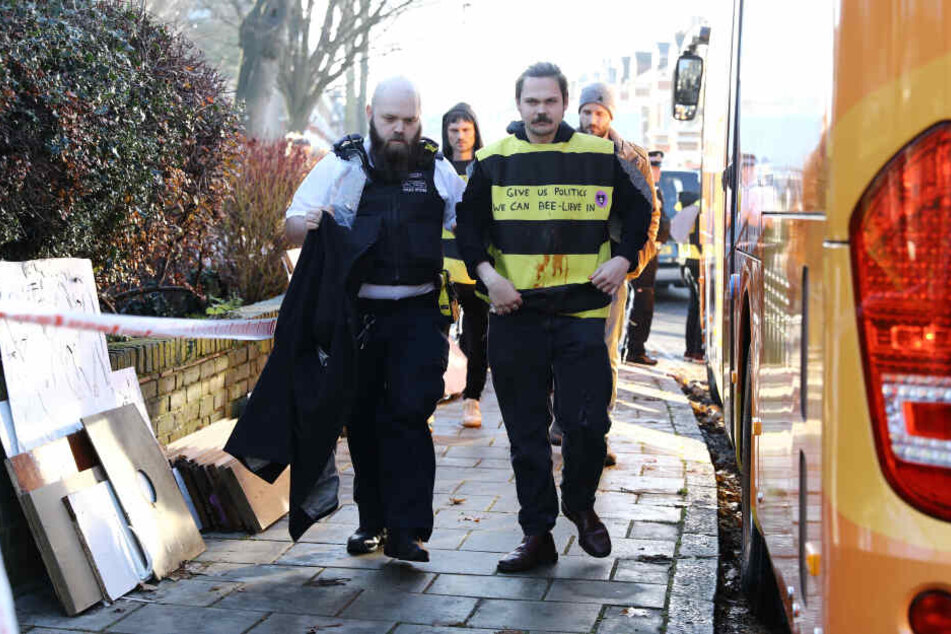 Ein Polizist führt einen verkleideten Demonstranten von "Extinction Rebellion" ab.
