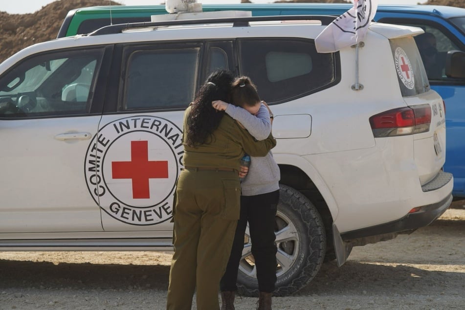 Das Bild zeigt eine Soldatin der Israelischen Verteidigungsstreitkräfte (IDF) und die freigelassene Geisel Agam Berger (r), die sich umarmen, als sie nach ihrer Freilassung durch die Hamas vom Roten Kreuz an die IDF übergeben wird.