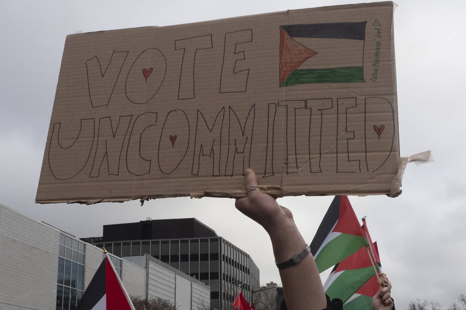 A Gaza solidarity protester carries a "Vote Uncommitted" sign during a march in Washington DC.