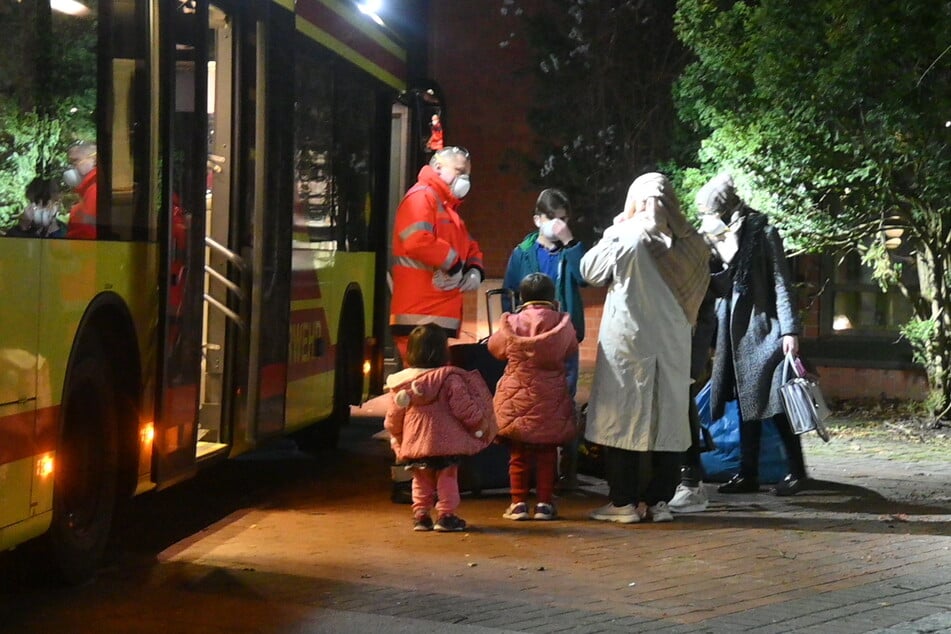 Menschen werden in Bussen zum Quarantäne-Standort gebracht.