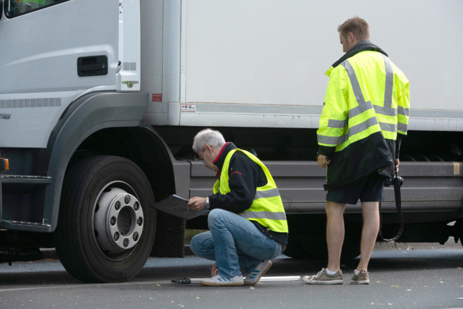 Verkehrsexperten sichern in Spandau an der Kreuzung Nauener Straße/Brunsbütteler Damm Spuren an einem Lkw.