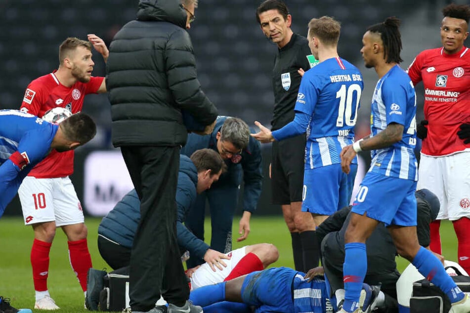 Nach Zusammenstoß liegen Jordan Torunarigha von Hertha BSC (r) und Stefan Bell von Mainz 05 verletzt am Boden.