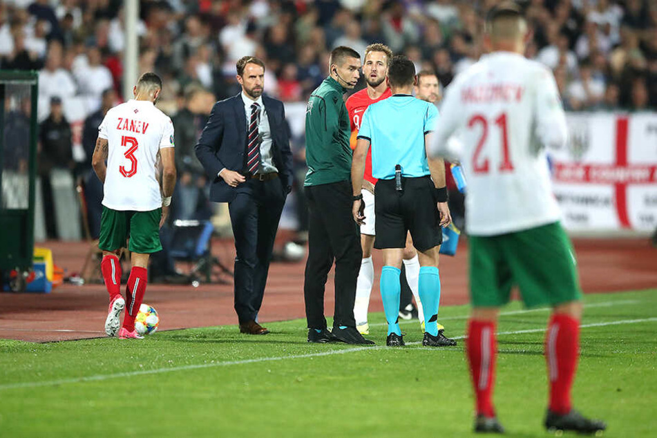 Schiedsrichter Bebek im Gespräch mit Harry Kane und dem vierten Offiziellen. Kurz darauf unterbricht der Unparteiische die Partie.
