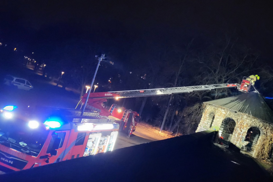 Mit einer Drehleiter löscht die Feuerwehr das brennende Dach der Bastion im Berliner Schillerpark.