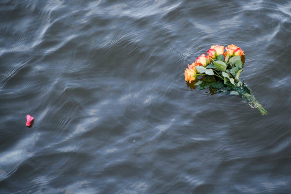 Bei einer Demonstration für Seenotrettung in Hamburg schwimmt ein Blumenstrauß im Wasser.