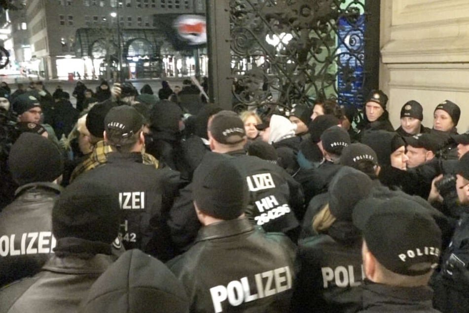Polizisten drängen die Demonstranten aus dem Rathaus.