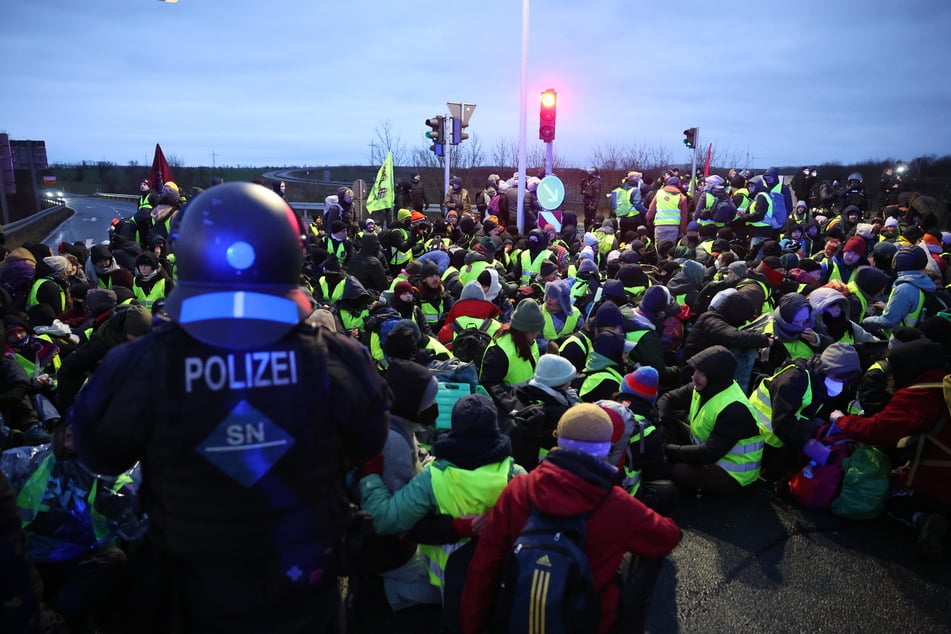 Mit Sitzblockaden und Klebe-Aktionen behindern die Demonstranten auch ihre eigenen Leute.