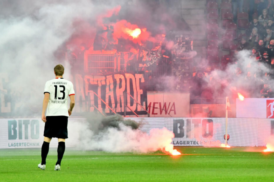 Martin Hinteregger steht vor der Fankurve der Eintracht-Anhänger. Durch deren Feuerwerk startete die Partie mit rund zehn Minuten Verspätung.