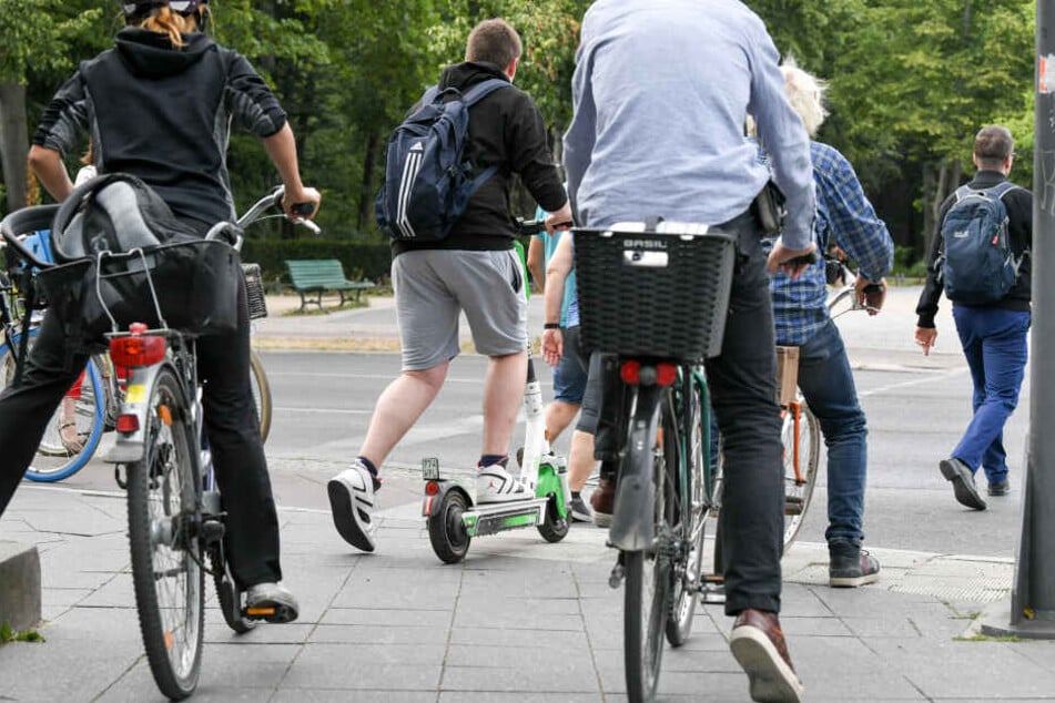 Ein E-Scooter-Fahrer im Straßenverkehr einer Großstadt.